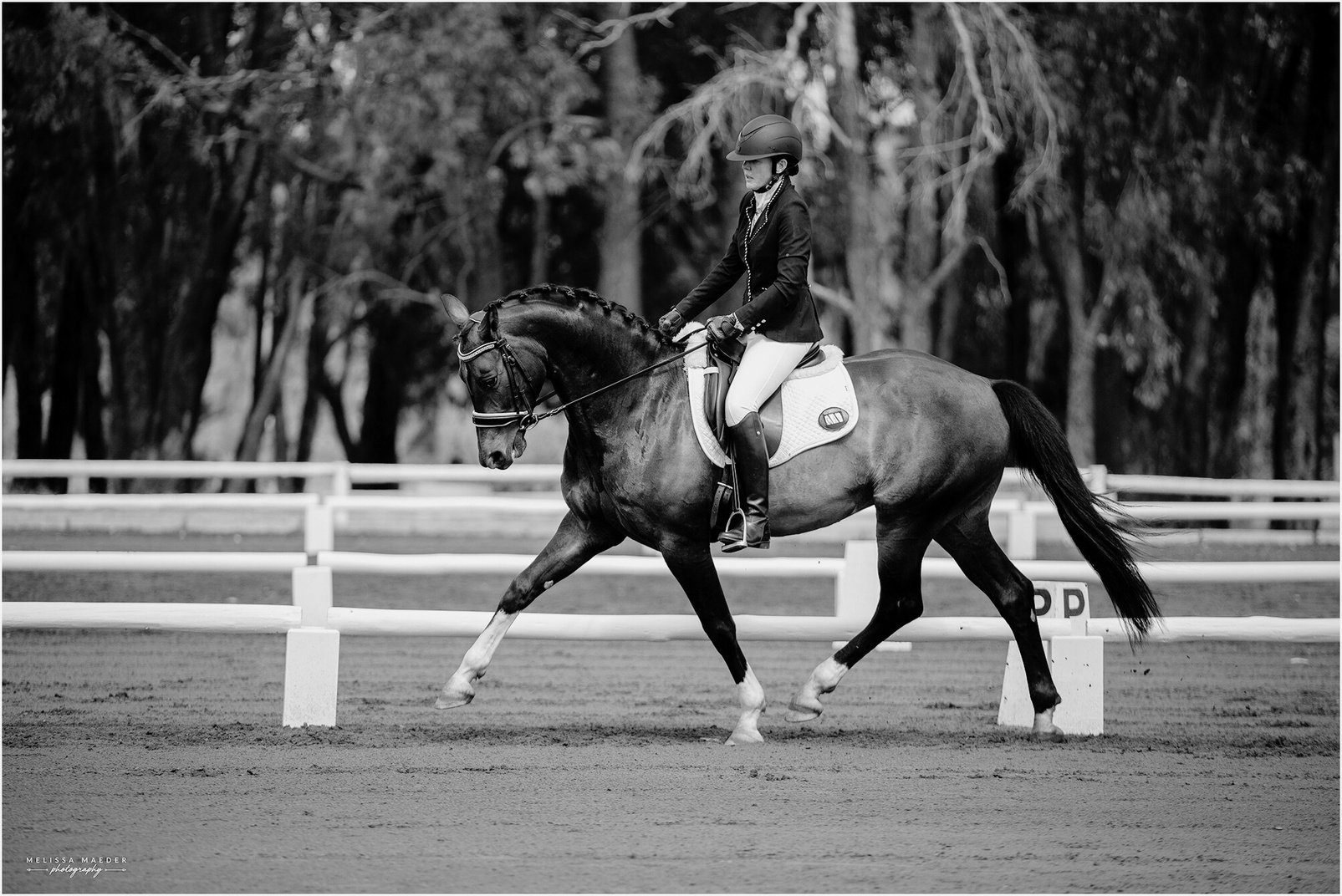 a black and white photo of a person riding a horse